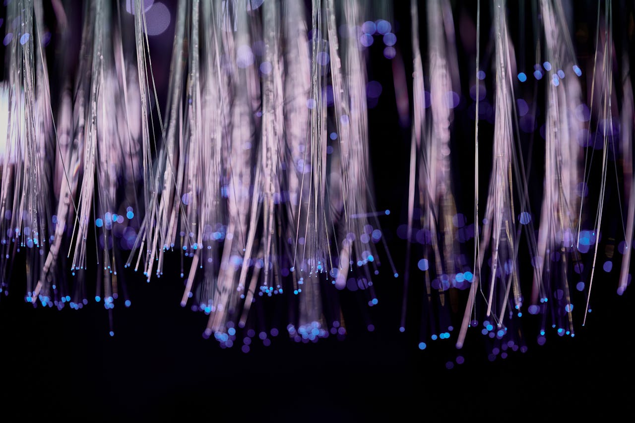 Close-up of glowing fiber optic lights with a purple and blue bokeh effect.